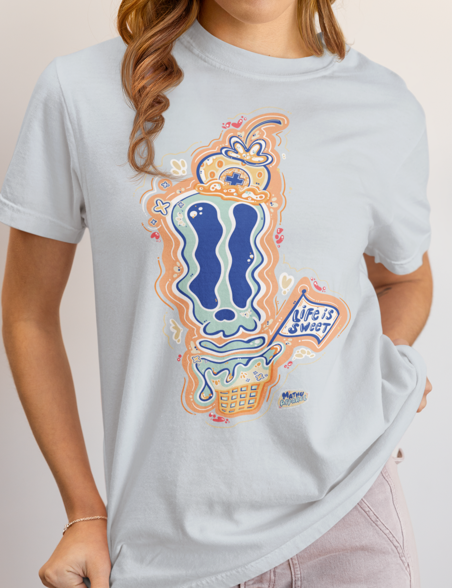 Person wearing a light blue t-shirt with a colorful graphic design on a plain background