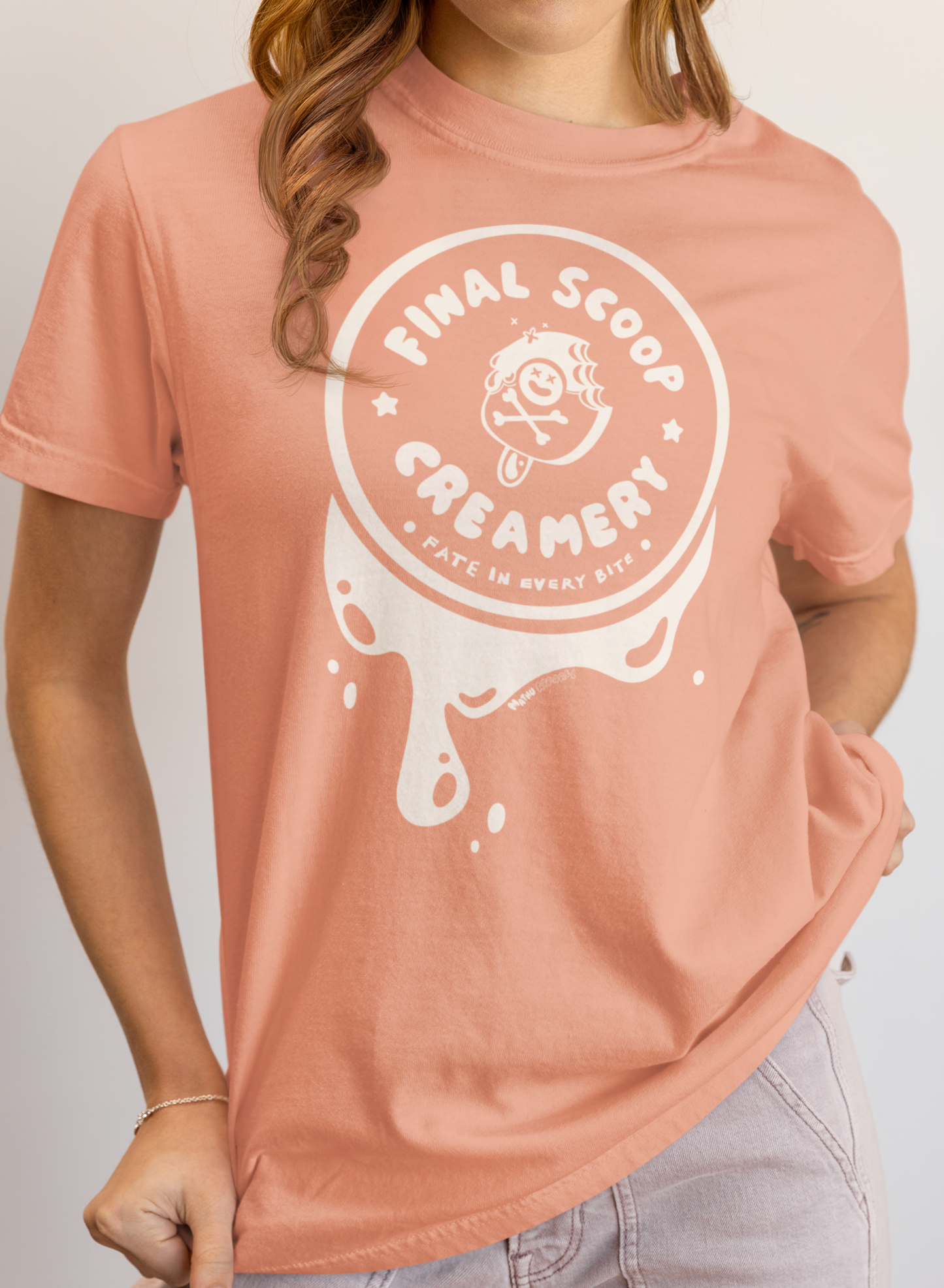 Person wearing a pink t-shirt with 'Final Scoop Creamery' logo on a plain background