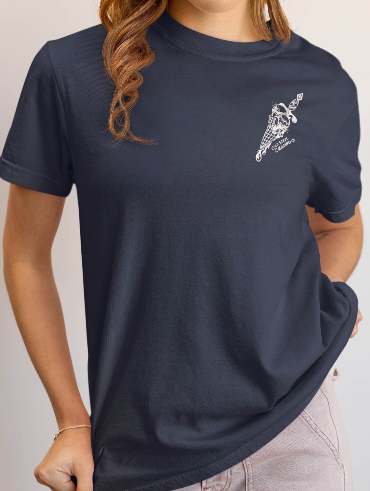 Person wearing a navy blue t-shirt with a logo on a plain background