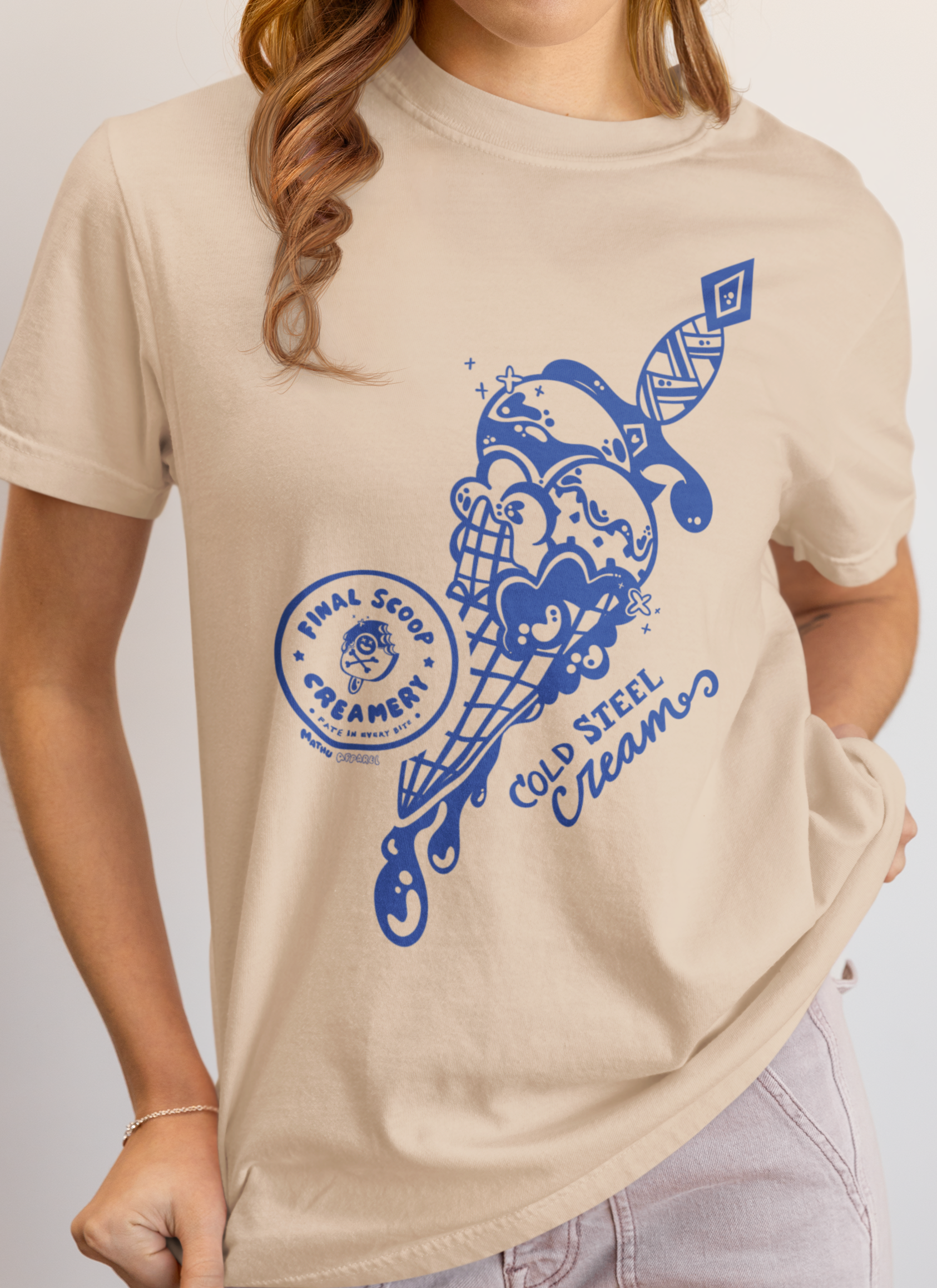 Person wearing a beige t-shirt with a blue graphic design on a plain background