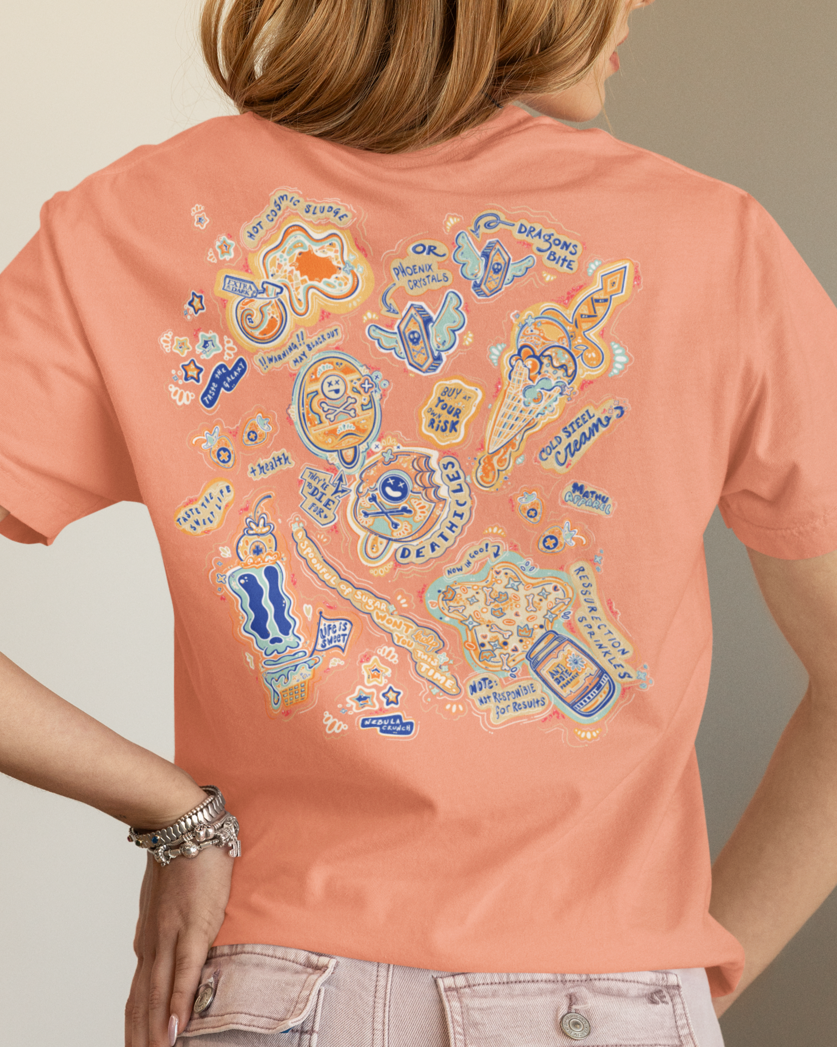 Person wearing a peach-colored t-shirt with colorful graphic design on the back.