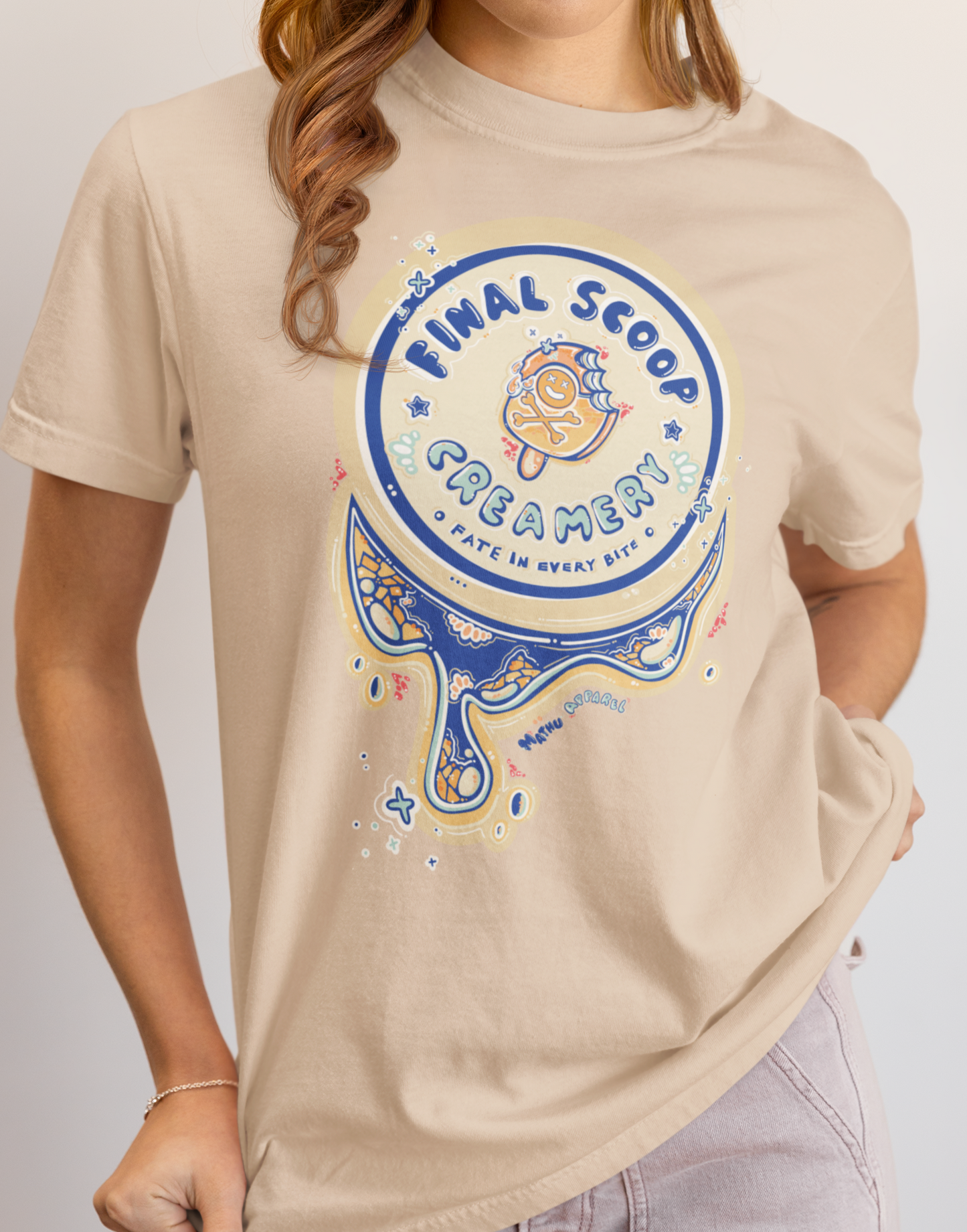 Person wearing a beige t-shirt with a 'Final Scoop Creamery' graphic design.